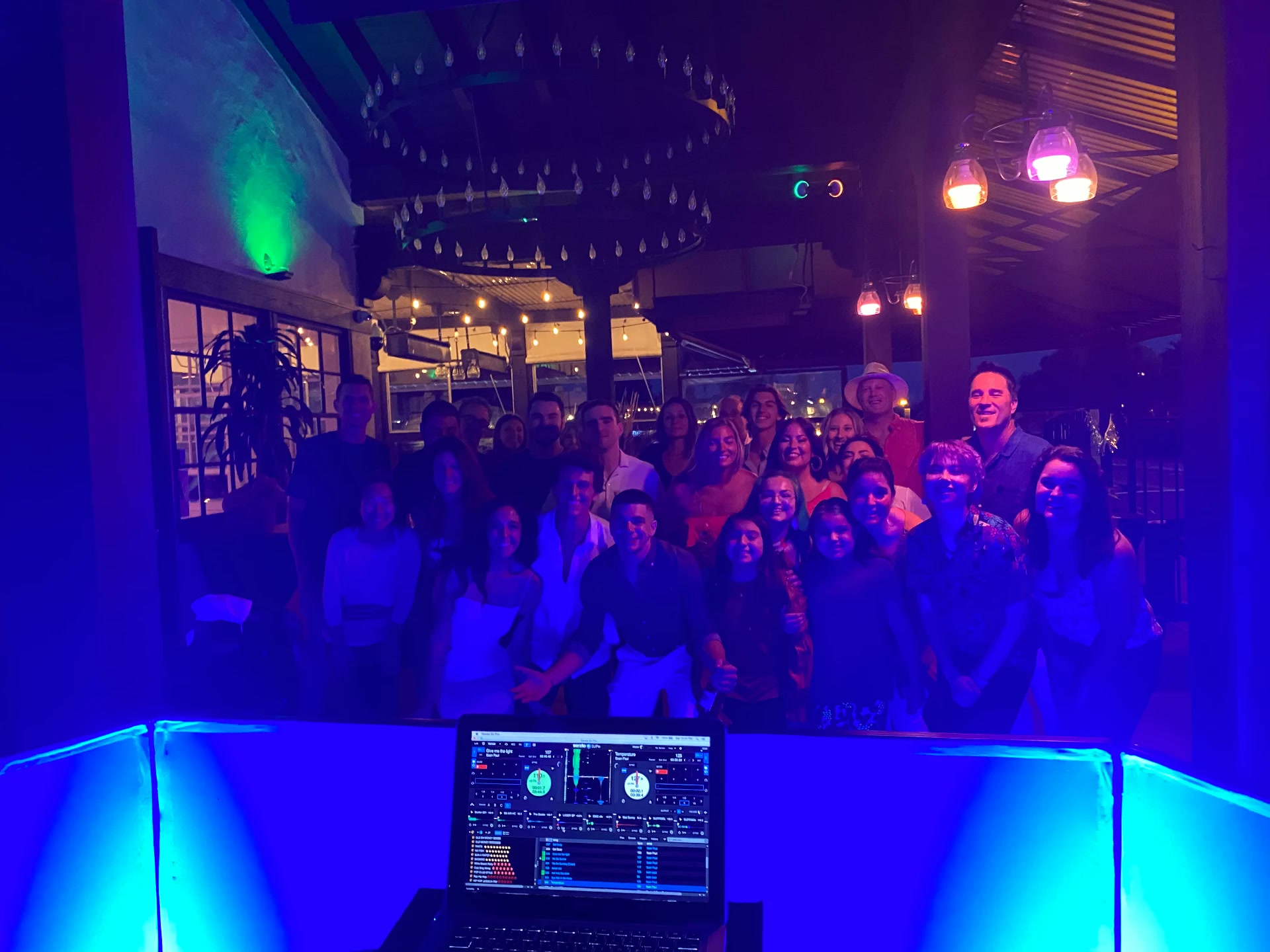 Crowd of party guests glowing under blue and purple uplighting