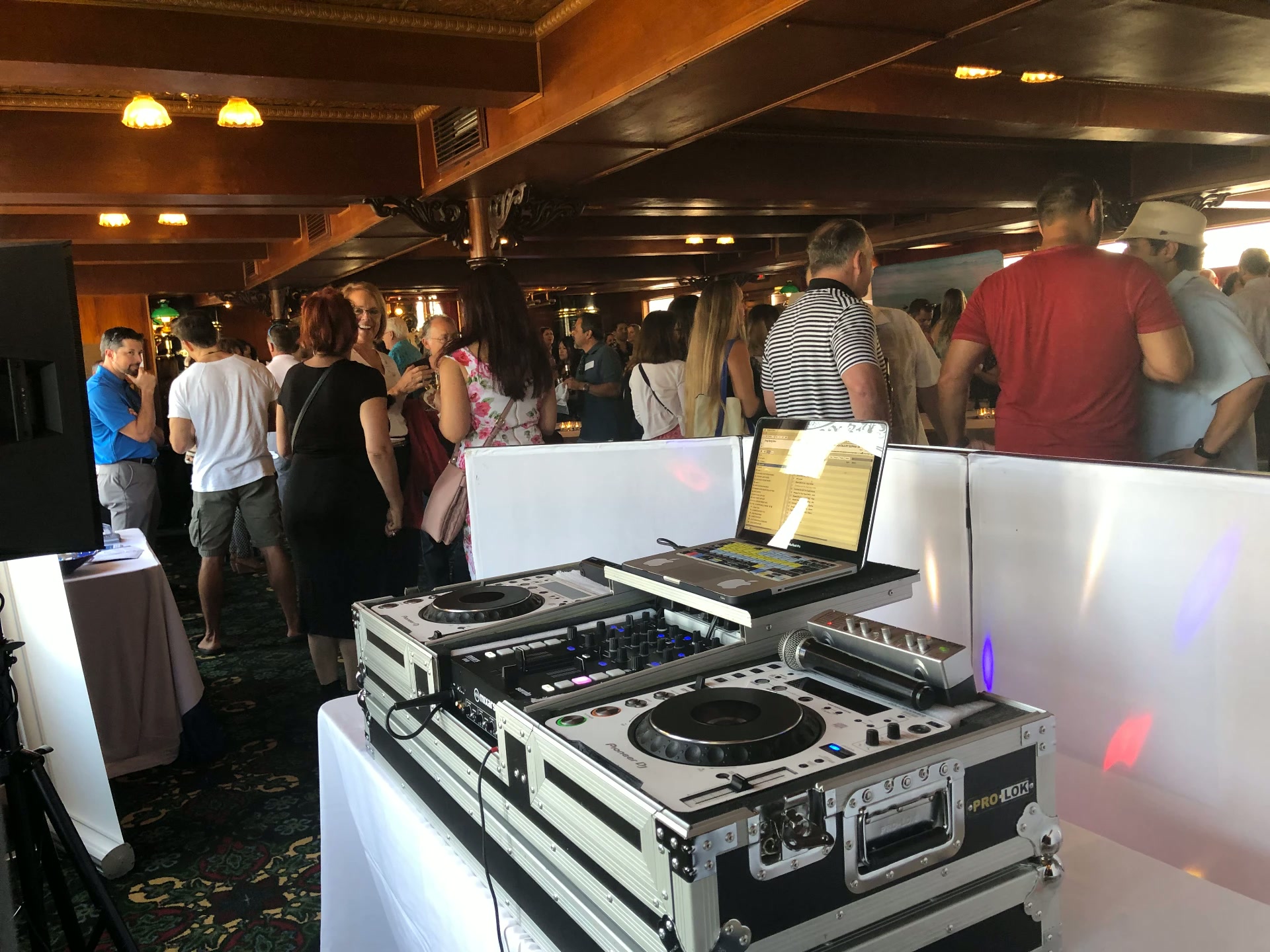 DJ booth with Pioneer gear at a crowded boat-deck party